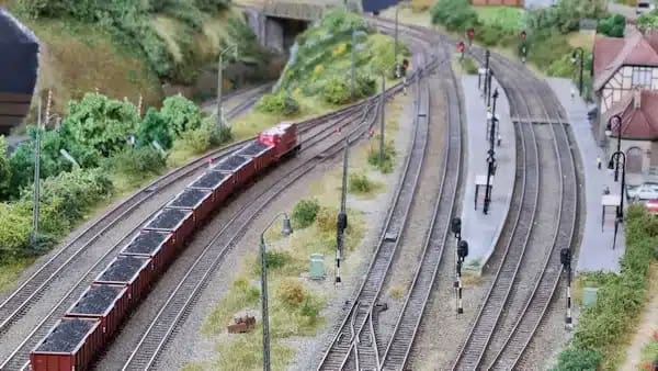 Even wat over ons 2 a model train tracks with a train on it